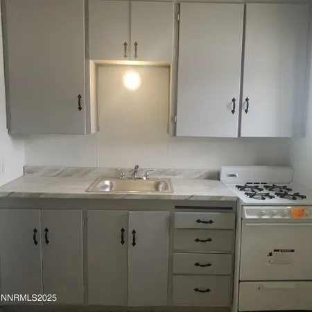 a room with a sink a stove and cabinets