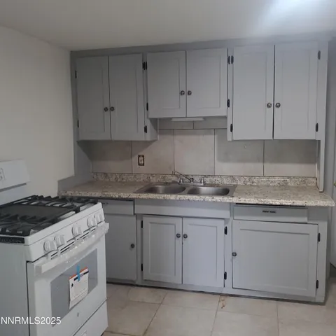 a kitchen with granite countertop white cabinets and white appliances