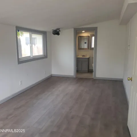 a view of an empty room with a window and closet area