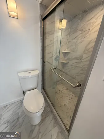 a bathroom with a toilet and a shower