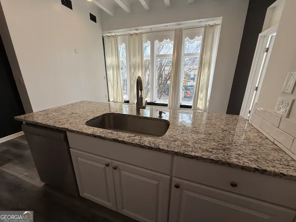 a kitchen with granite countertop a sink and cabinets