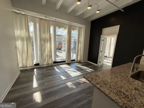 a view of a livingroom with wooden floor and a window