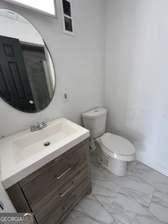 a bathroom with a toilet sink and mirror