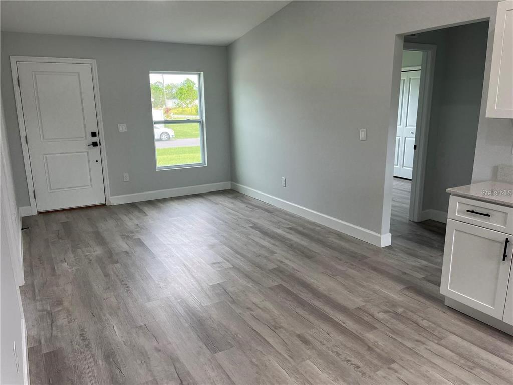 7209 Ancha Street Sebring, FL 33872 - Photo 2 of 18 an empty room with wooden floor and windows