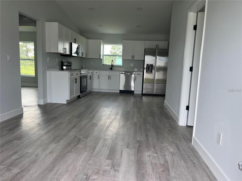 7209 Ancha Street Sebring, FL 33872 - Photo 3 of 18 a view of a kitchen with cabinets and wooden floor