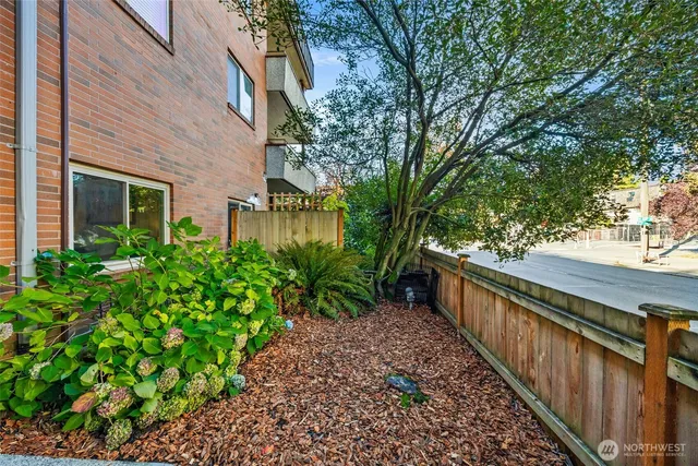 a view of a house with a large windows and flower plants