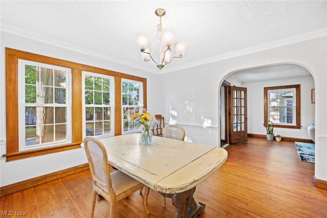 3962 Orchard Road Cleveland Heights, OH 44121 - Photo 12 of 35 Dining room with a textured ceiling, a healthy amount of sunlight, crown molding, and light hardwood floors