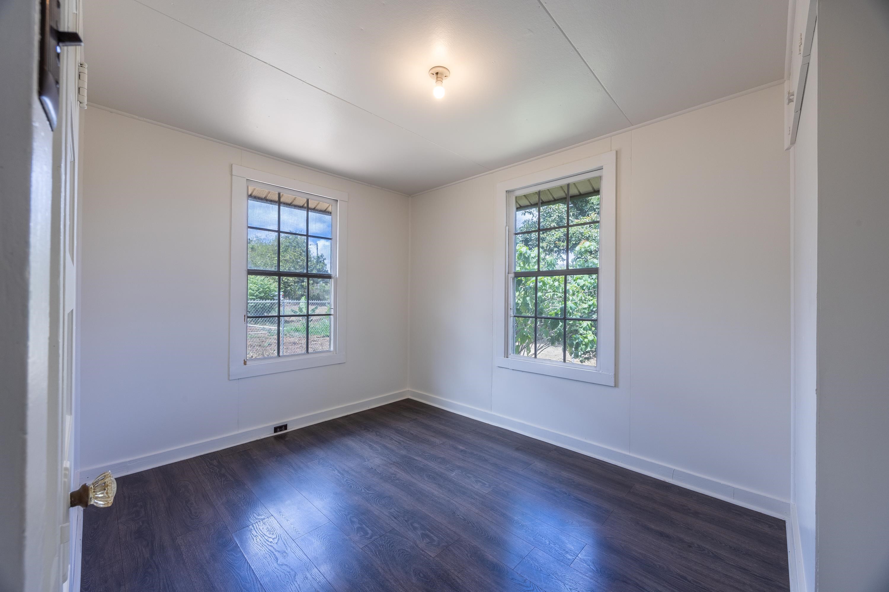 3044 Lower Kula Road Kula, HI 96790 - Photo 41 of 44 an empty room with wooden floor and windows