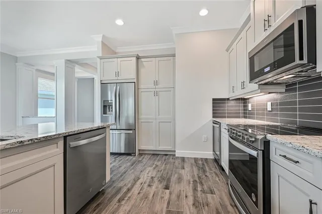 a kitchen with stainless steel appliances granite countertop a stove and a refrigerator