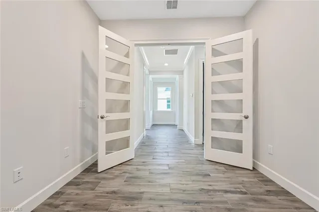 an empty room with wooden floor and white walls
