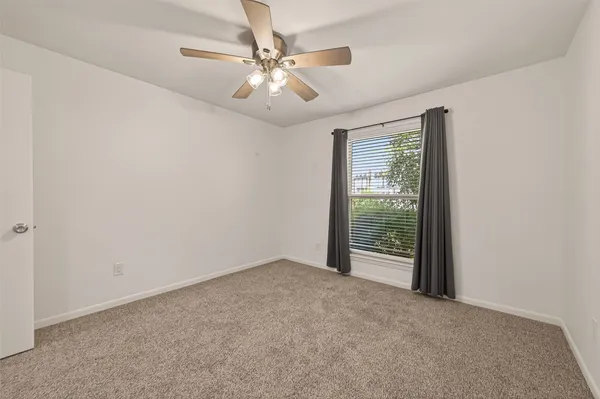 an empty room with chandelier fan