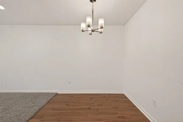 a view of a chandelier fan and hardwood floor