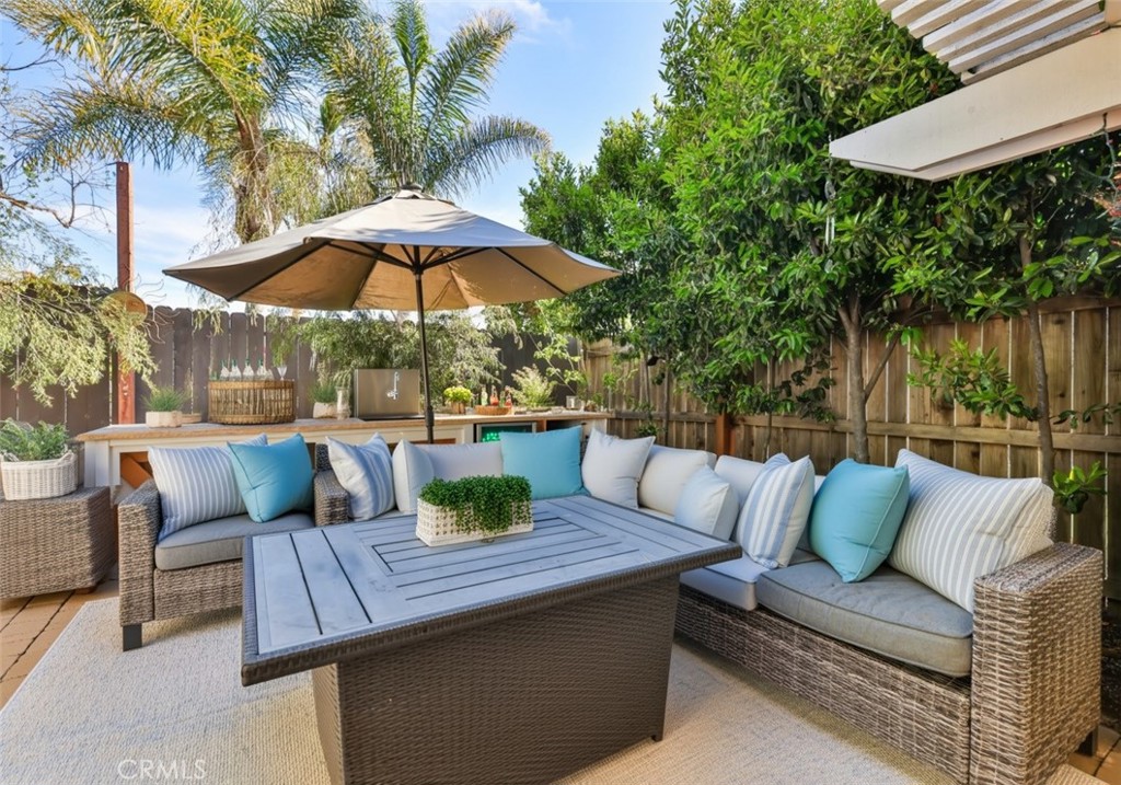 3014 Enrique, Unit 98 San Clemente, CA 92673 - Photo 2 of 14 a view of patio with couches table and chairs under an umbrella with a barbeque