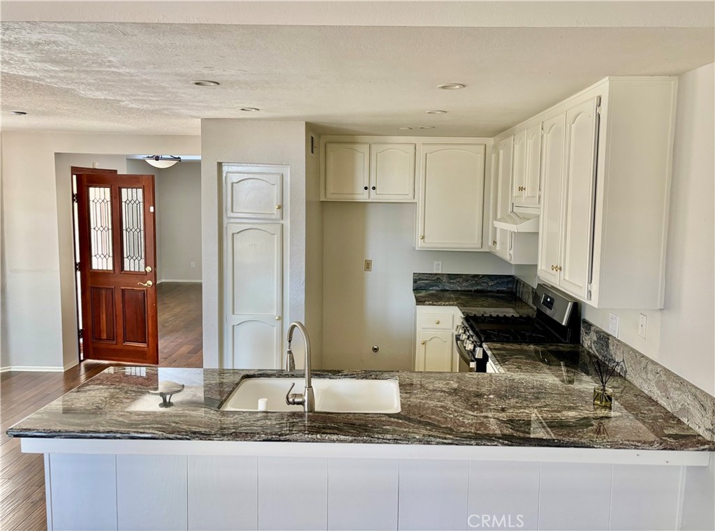 3014 Enrique, Unit 98 San Clemente, CA 92673 - Photo 5 of 14 a bathroom with a granite countertop sink and a mirror