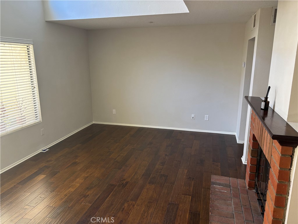 3014 Enrique, Unit 98 San Clemente, CA 92673 - Photo 8 of 14 an empty room with wooden floor and a window