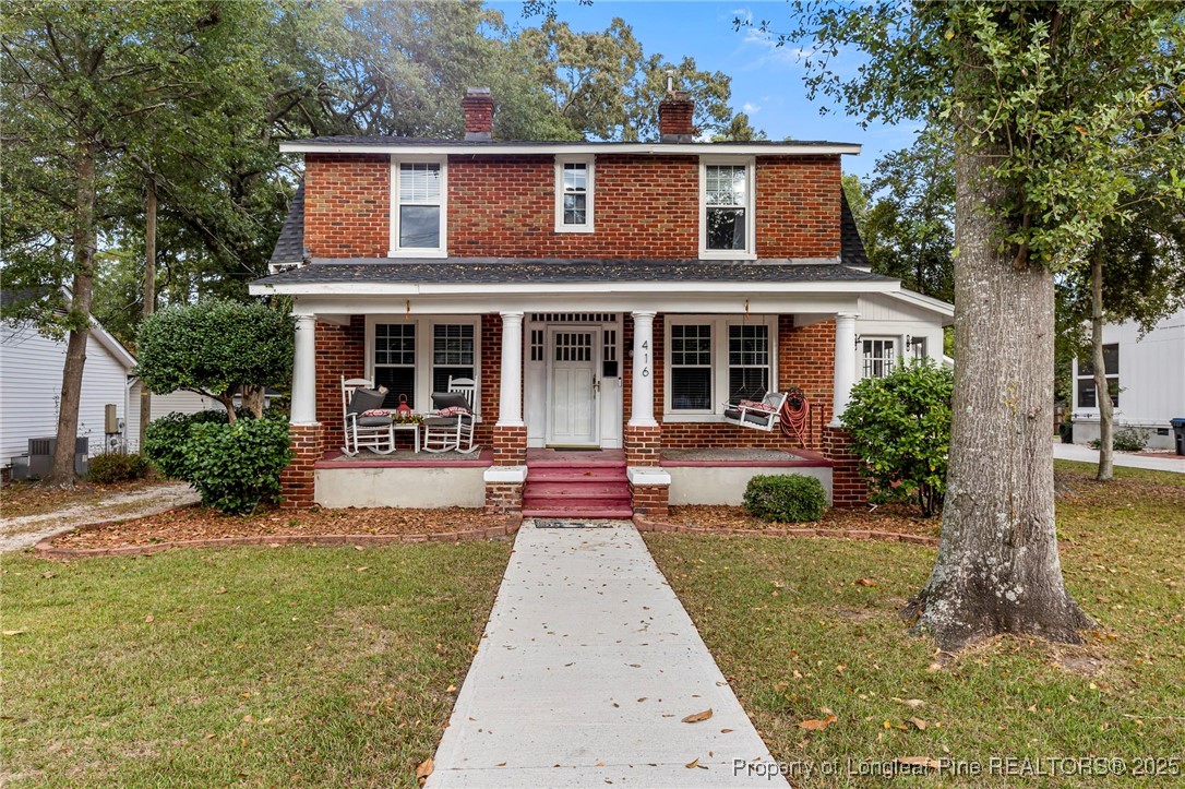 a front view of a house with yard and green space