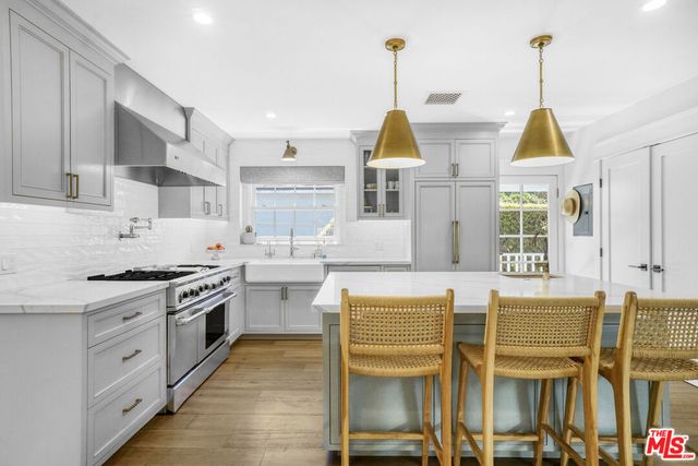 a kitchen with stainless steel appliances granite countertop a stove and a wooden floors
