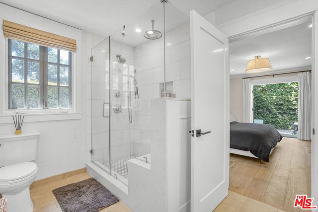 a bathroom with a granite countertop sink a toilet and shower