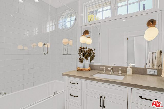 a bathroom with a sink a mirror and a shower