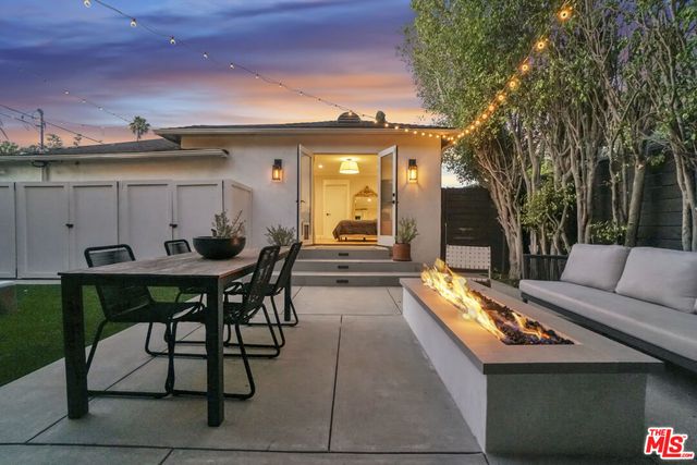a view of a patio with couches table and chairs with wooden floor and fence