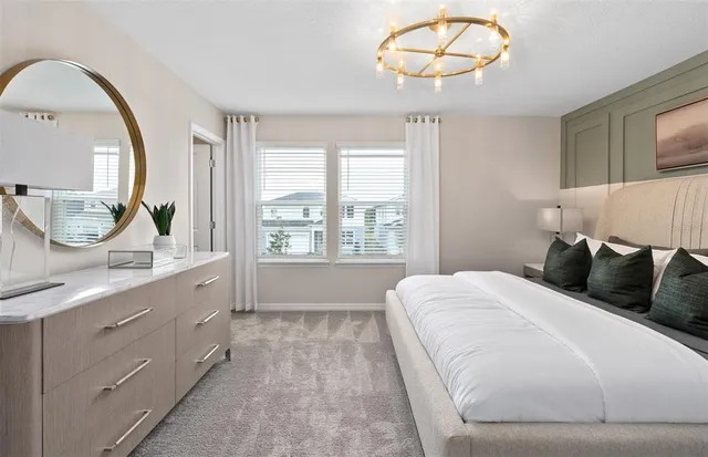 a bedroom with a large bed and a chandelier