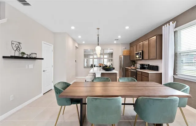 a kitchen with stainless steel appliances granite countertop a kitchen island a stove a table and chairs