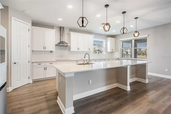 a large kitchen with cabinets and wooden floor