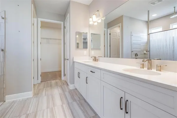 a spacious bathroom with a double vanity sink and mirror