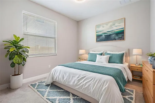 a bedroom with bed and a potted plant