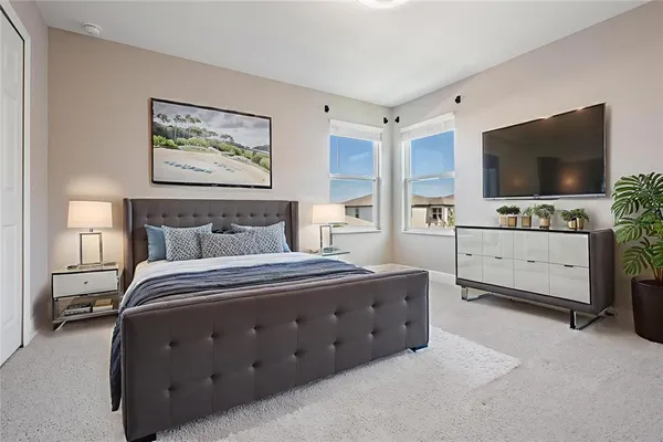 a spacious bedroom with a bed and a flat screen tv