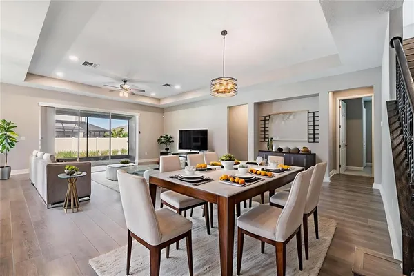 a dining room with furniture a chandelier and wooden floor