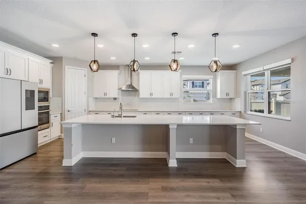 a view with granite countertop a sink cabinets and wooden floor