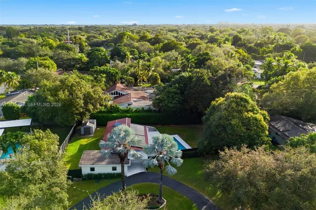 an aerial view of a house with a garden and lake view