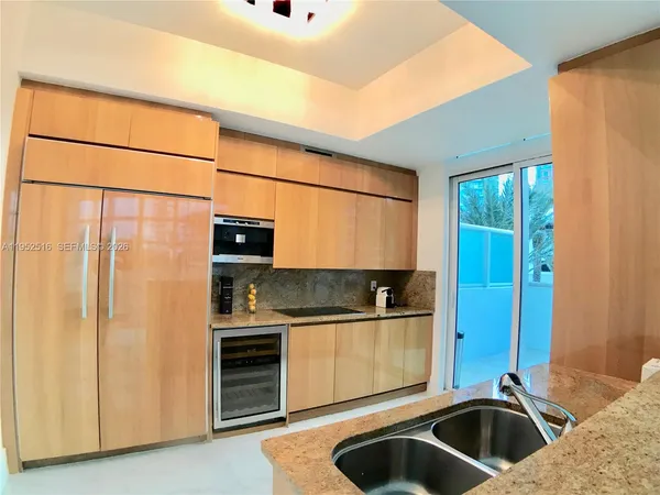 a kitchen with stainless steel appliances a sink and a refrigerator
