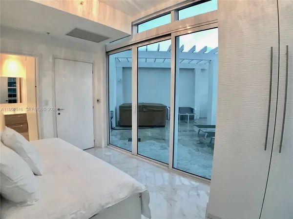 a bedroom with a balcony and walk in closet