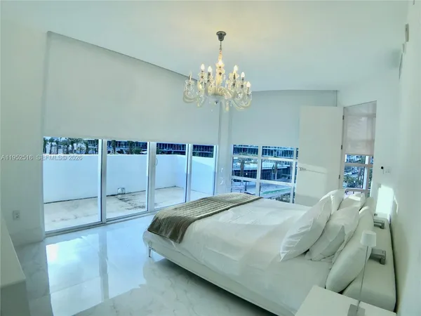 a bedroom with a large bed and a chandelier
