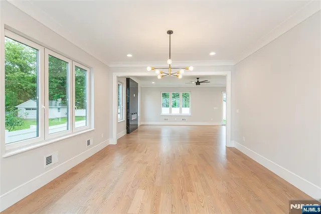 a view of an empty room with stairs and a window