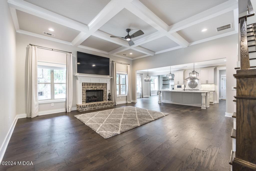 411 Crescent Drive Forsyth, GA 31029 - Photo 14 of 57 a living room with stainless steel appliances kitchen island granite countertop furniture and a fireplace