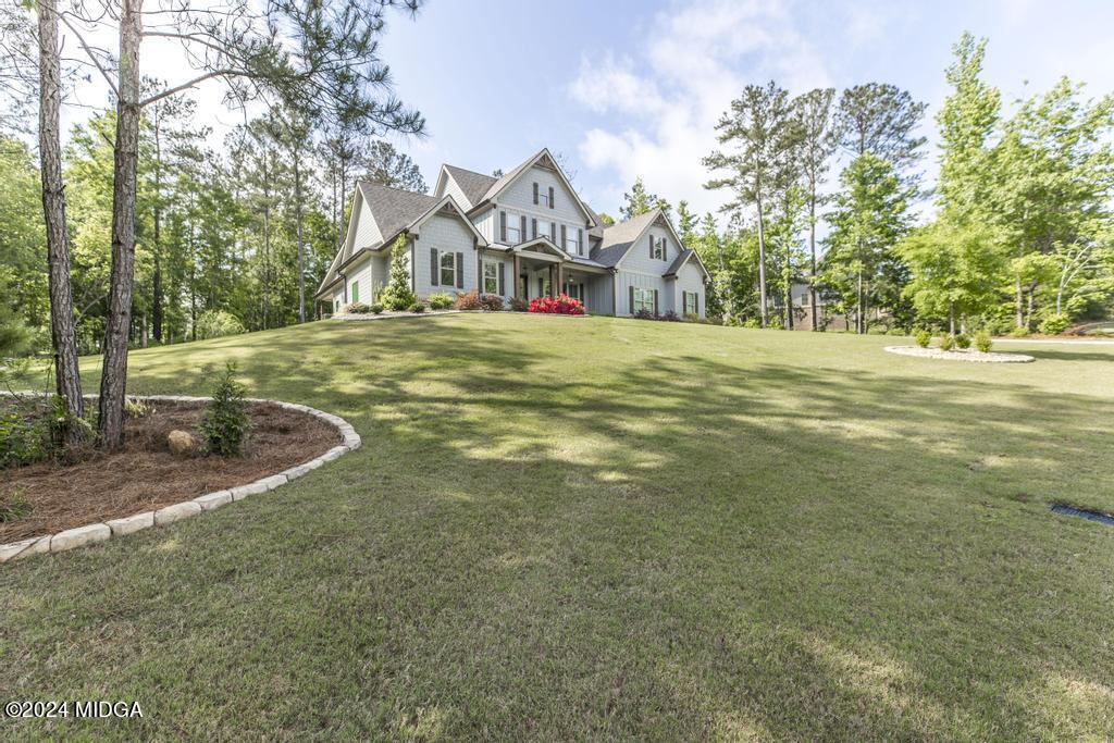 411 Crescent Drive Forsyth, GA 31029 - Photo 8 of 57 a view of a white house with a big yard and large trees