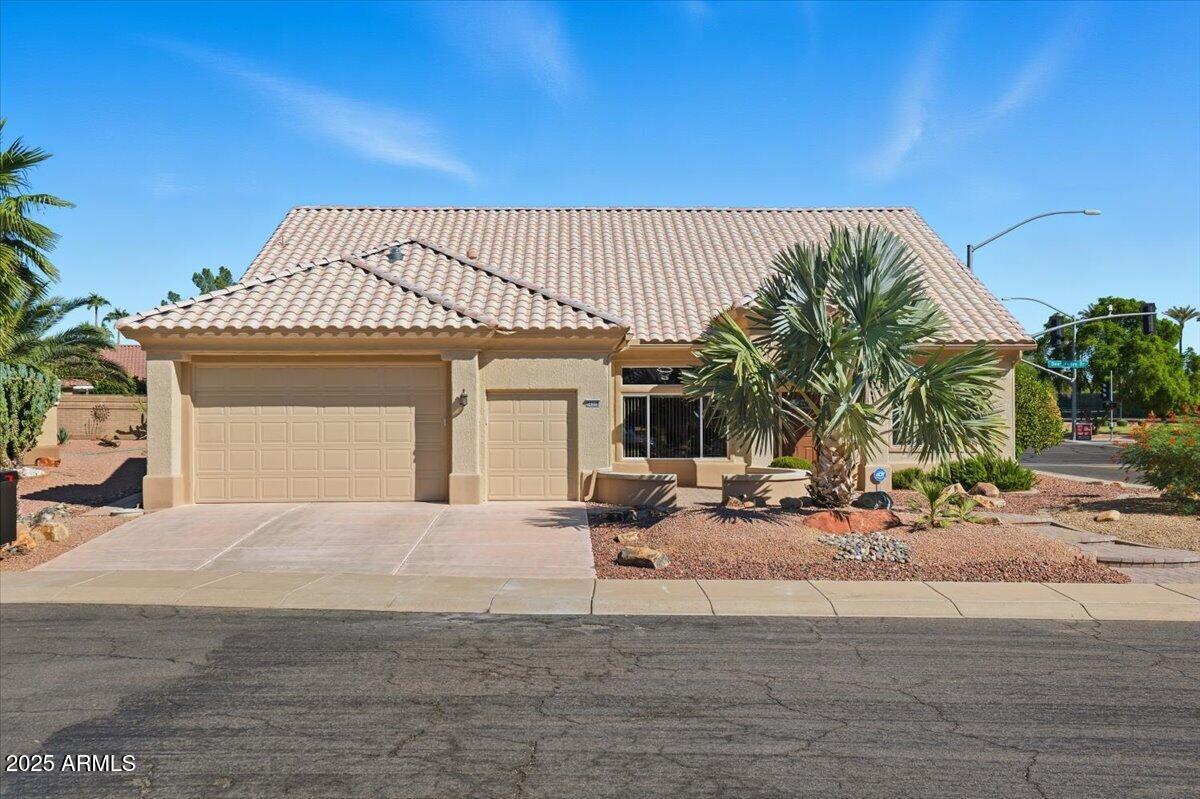 22318 North Dusty Trail Boulevard Sun City West, AZ 85375 - Photo 1 of 66 a front view of a house with garden and garage