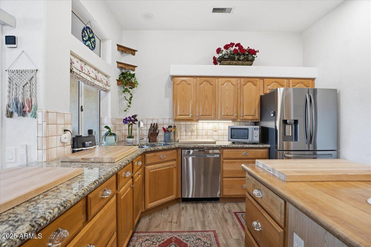 22318 North Dusty Trail Boulevard Sun City West, AZ 85375 - Photo 17 of 66 a kitchen with stainless steel appliances a sink stove and refrigerator