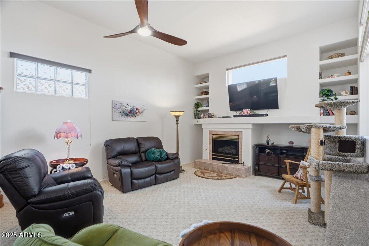 22318 North Dusty Trail Boulevard Sun City West, AZ 85375 - Photo 23 of 66 a living room with furniture a flat screen tv and a fireplace