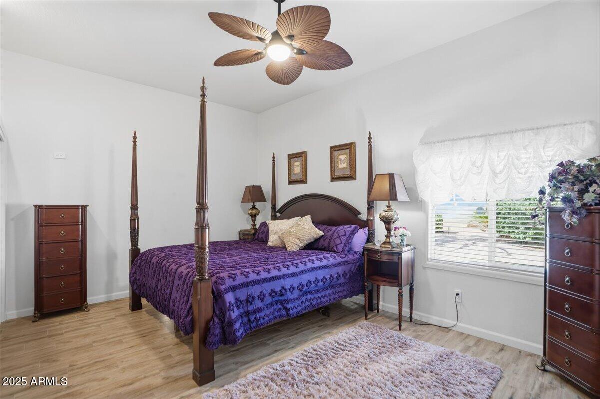 22318 North Dusty Trail Boulevard Sun City West, AZ 85375 - Photo 36 of 66 a bedroom with a large bed and a chandelier