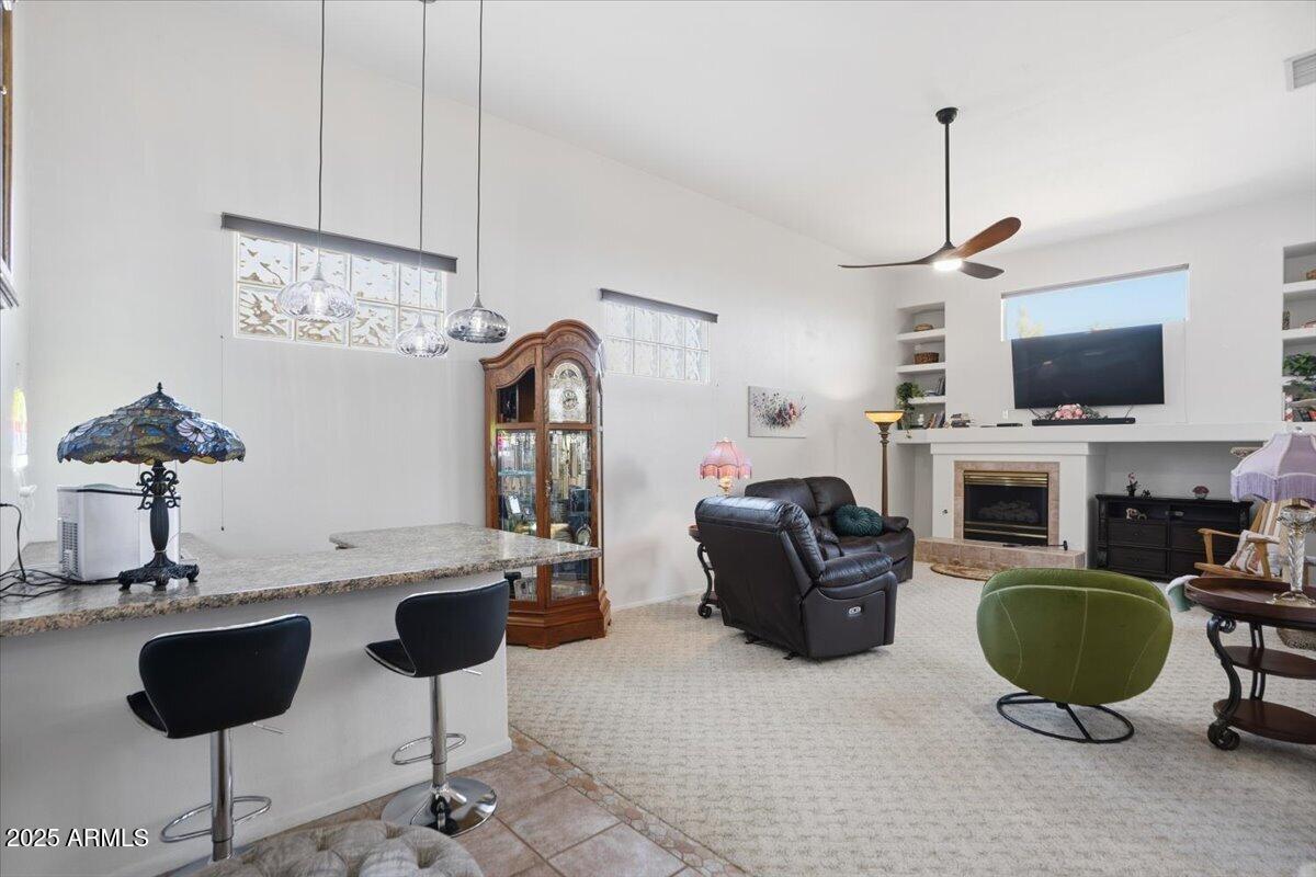22318 North Dusty Trail Boulevard Sun City West, AZ 85375 - Photo 3 of 66 a living room with furniture a flat screen tv and a fireplace