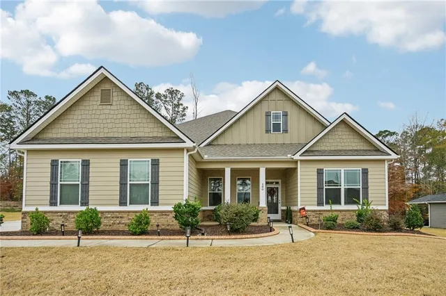 a front view of a house with garden and plants