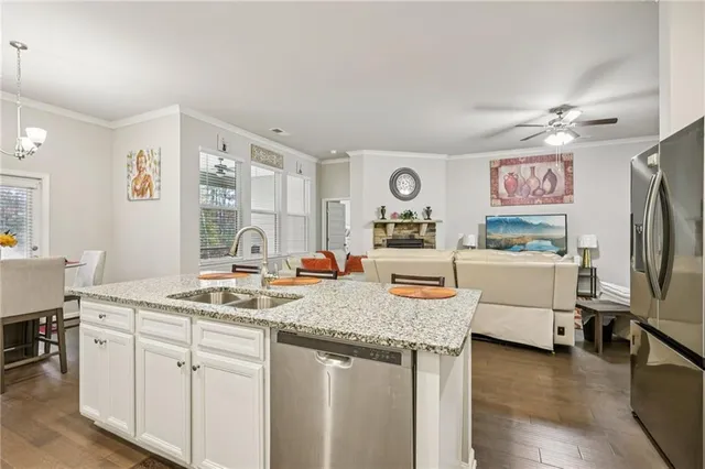 a view of kitchen island with stainless steel appliances granite countertop a stove a sink and a refrigerator