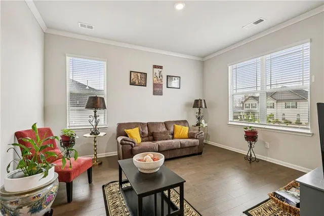 a living room with furniture wall paintings and a window