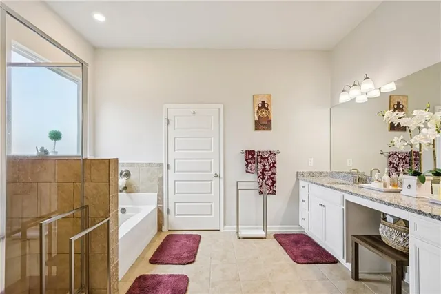 a en suite bathroom with a granite countertop sink and a mirror