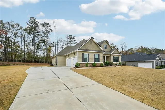 a front view of a house with a yard and trees