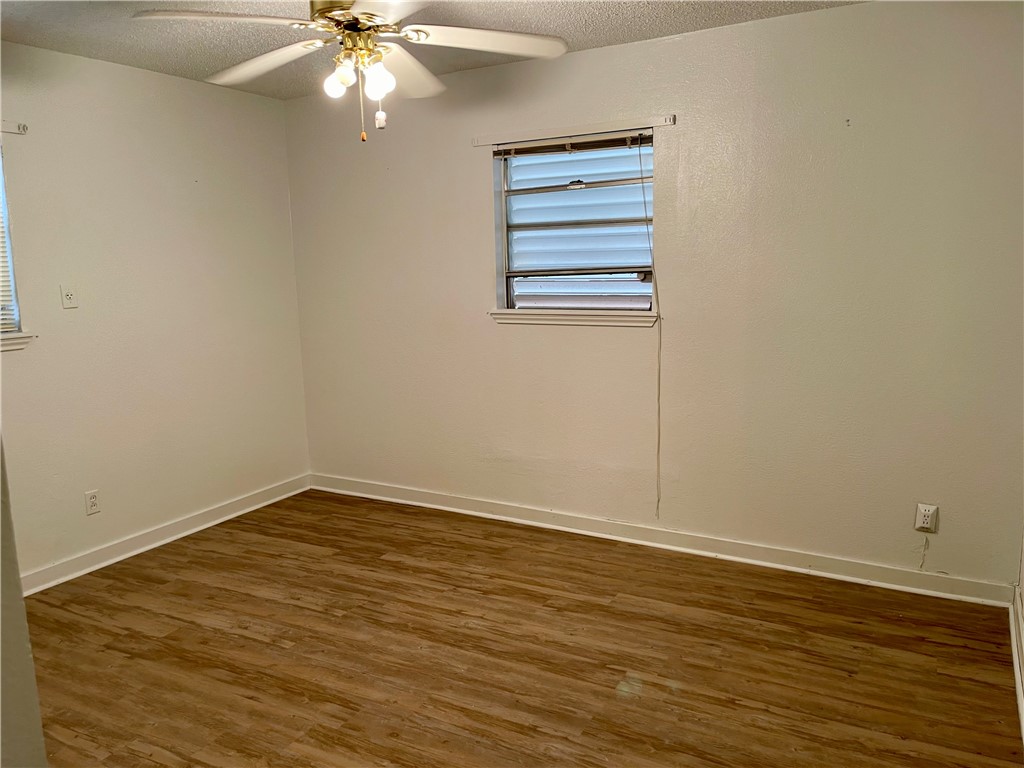 1101 Dewey Avenue Alice, TX 78332 - Photo 15 of 17 a view of an empty room with wooden floor and a window